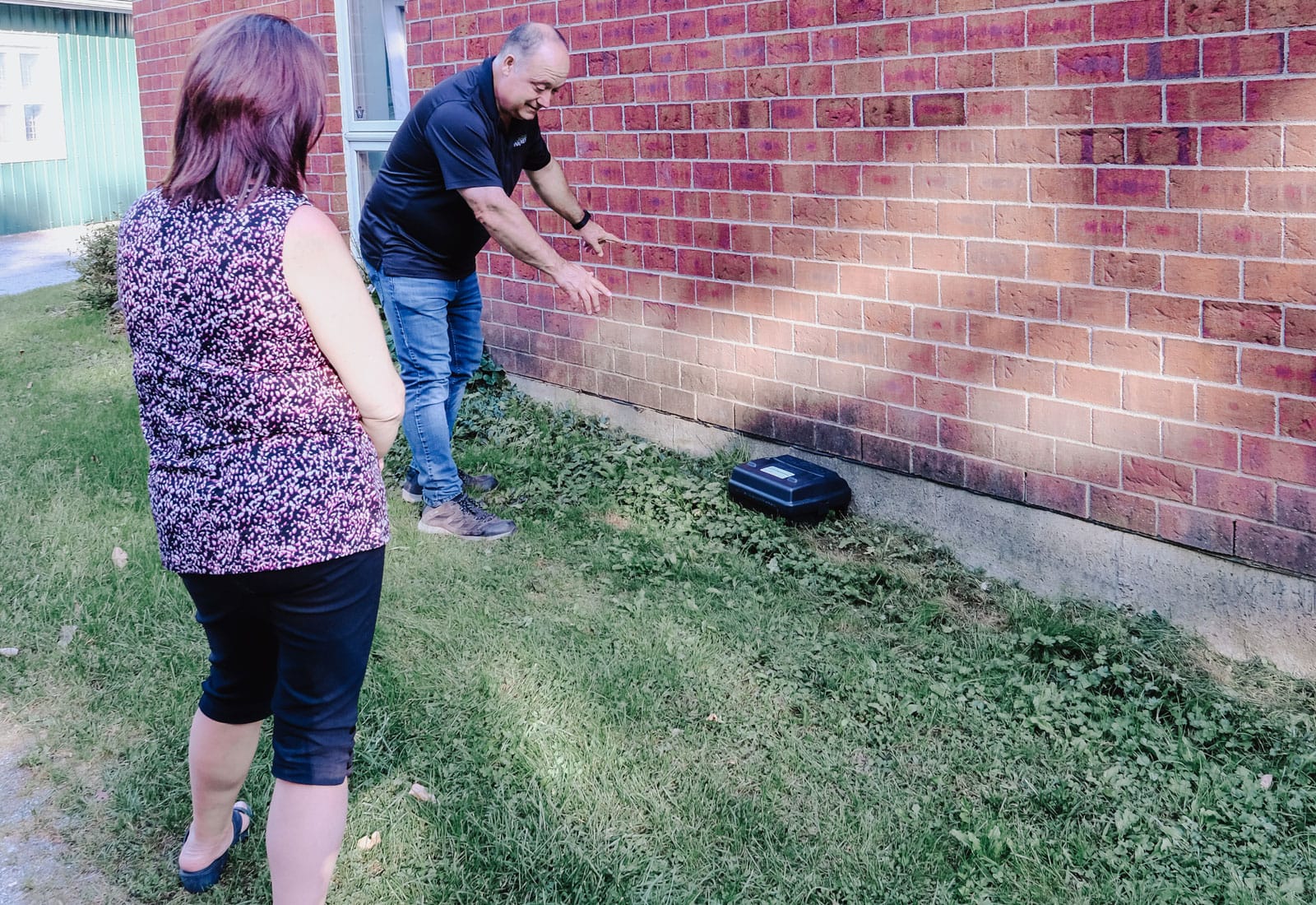 Exterminateur donnant des explications a une cliente apres l'installation de boite anti-rongeurs.