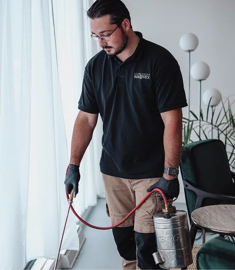 Exterminateur faisant un traitement a l'interieur d'une maison.